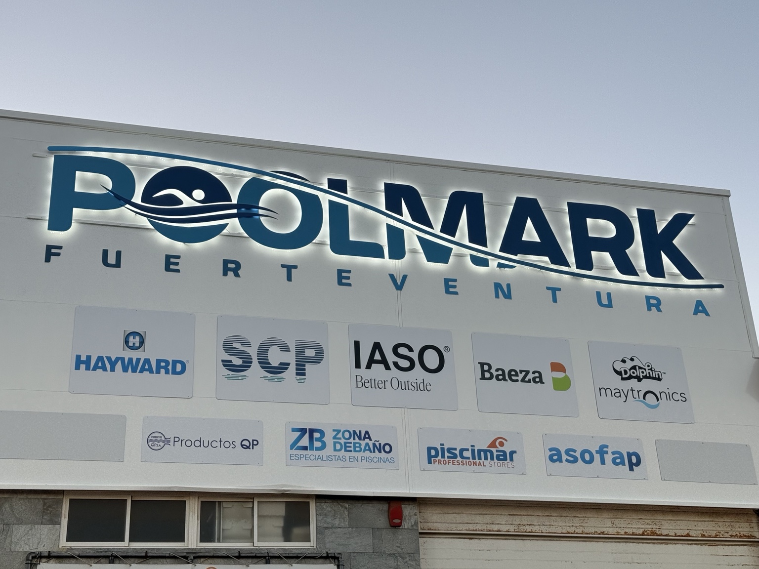 Rótulo iluminado Poolmark Fuerteventura instalado en fachada